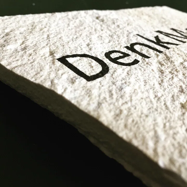Schrift als Individualdruck auf einer strukturierten Natursteinfläche